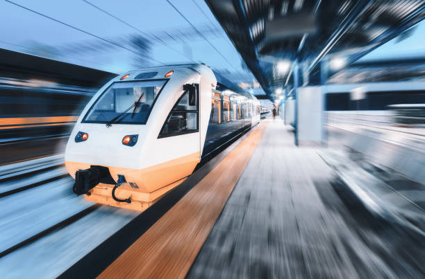 istock High speed train in motion on the railway station at night. Modern intercity passenger train with motion blur effect on the railway platform. Industrial. Railroad in Europe. Commercial transportation 1296380562