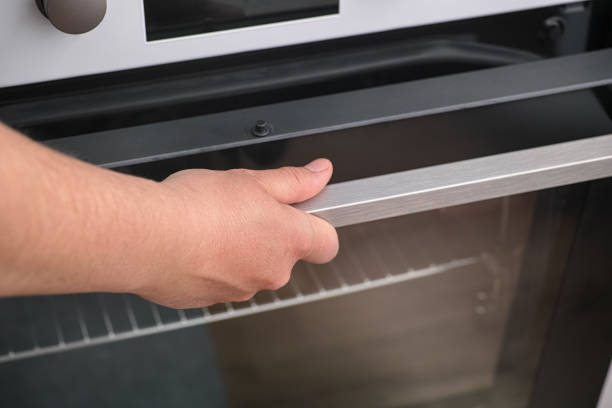 istock Woman opening an oven 1296383831