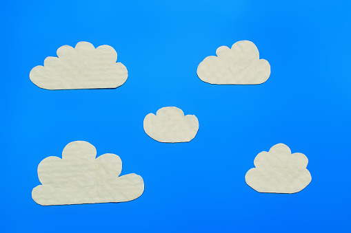 cardboard clouds on a blue background in cartoon style