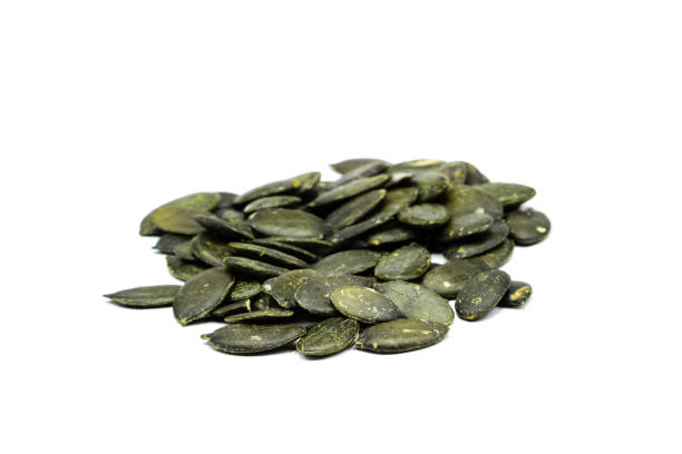istock Pumpkin seeds from top isolated on white background 1296388725