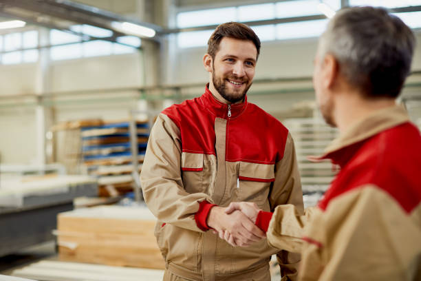 istock Happy male workers greeting at carpentry workshop. 1296388751