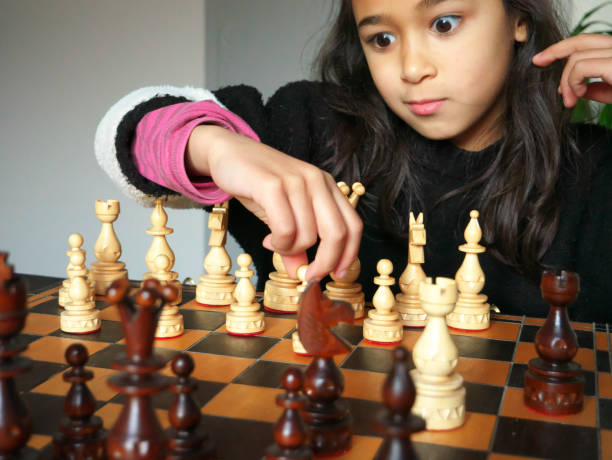 istock Little girl playing chess with a surprised look on her face. 1296390354