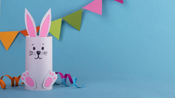 istock cute Easter bunny made of paper on a blue background, handmade, space for text. easter background 1296391374