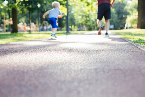 father and son running in park - healthy lifestyle nature sports shoe childhood imagens e fotografias de stock