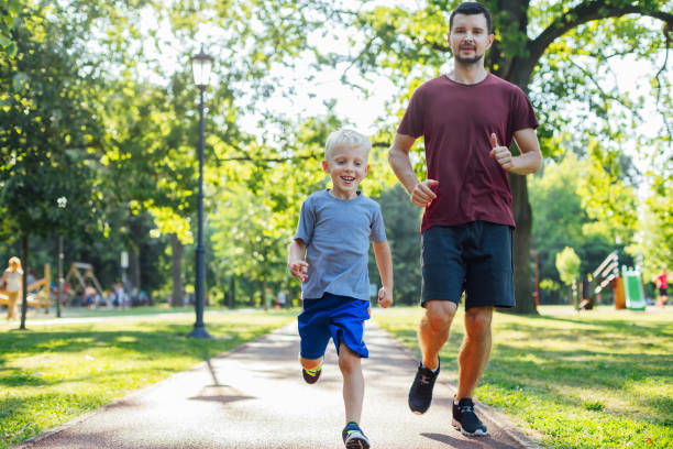 Father and son running together in the park.