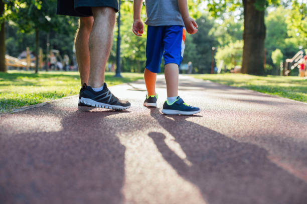отец и сын готовятся к бегу - healthy lifestyle nature sports shoe childhood стоковые фото и изображения