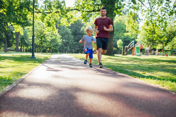 father and son running together - healthy lifestyle nature sports shoe childhood imagens e fotografias de stock
