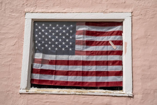 istock An American flag hanging in a window on a peach painted building 1296392488