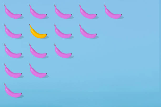 istock Trendy Summer pattern made with fresh banana fruit colored in pink on bright light blue background. 1296392521