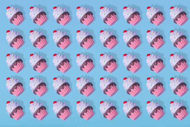 istock Trendy colorful cupcake pattern on pastel blue background. 1296392523