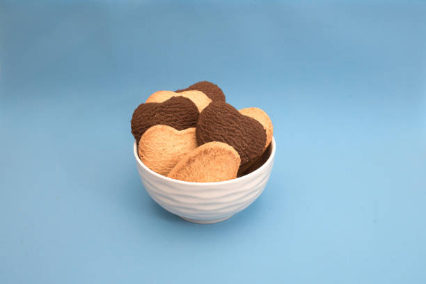 istock White plate with multi-colored heart-shaped cookies on a blue background 1296392684