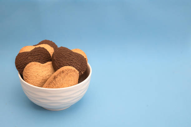istock White plate with multi-colored heart-shaped cookies on a blue background 1296392699