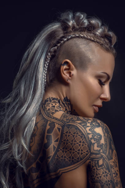 verticale latérale d’une femelle blonde viking tatouée et de sa coiffure unique - tatouage femme photos et images de collection