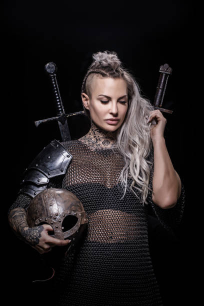 istock Sword wielding viking warrior blonde female in studio shot 1296395071