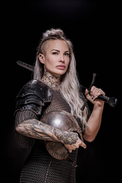 istock Sword wielding viking warrior blonde female in studio shot 1296395080