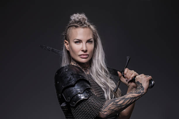 istock Sword wielding viking warrior blonde female in studio shot 1296395133