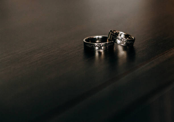 istock gold wedding rings wooden dark background backlight 1296399264