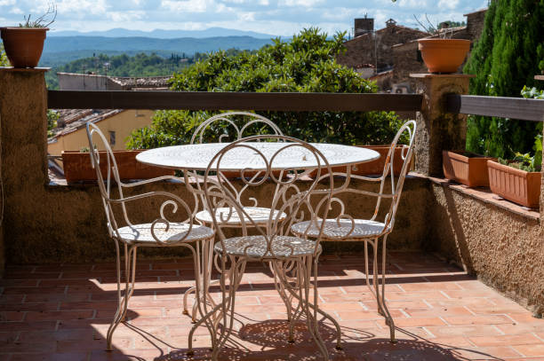 Travel destination, iron table and chairs in small ancient village Cotignac in Var, Provence, surrounded by vineyards and cliffs with troglodytes houses.
