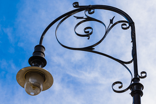 An old street lamp against a blue sky.
