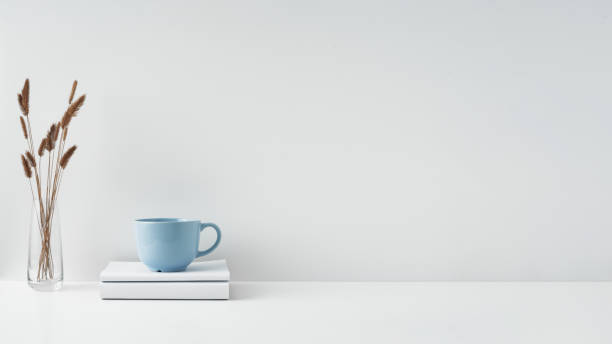 istock The mug stands on a stack of books on a white background. Natural and eco-friendly materials. Copy space, mock up. 1296408771