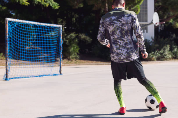 istock soccer player kicking the ball into empty goal 1296409582