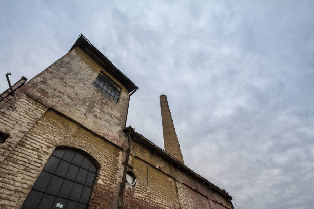 istock Abandoned factory and warehouse with its distinctive brick chimney in Eastern Europe, in Belgrade Serbia, former Yugoslavia, during a cloudy afternoon. 1296413321