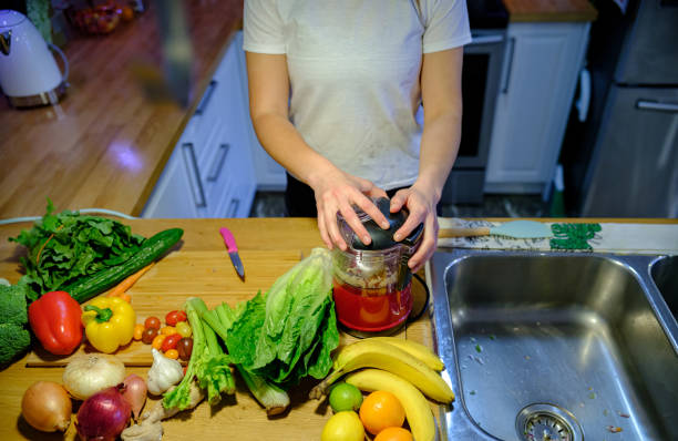 istock Woman chopping vegetables in blender 1296414130