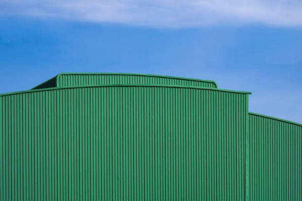 istock Green corrugated metal warehouse building against blue sky 1296414991