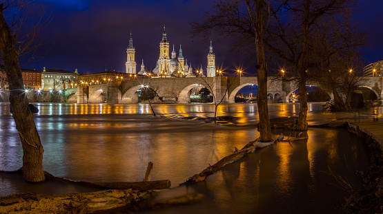 Zaragoza - The bridge Puente de Piedra and Basilica del Pilar with the riverside of Ebro river at dusk.