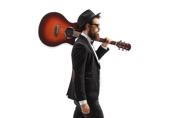 istock Musician walking with an acoustic guitar on his shoulder 1296416767