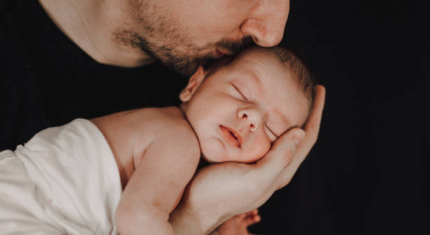 istock Father kissing his newborn baby 1296422964