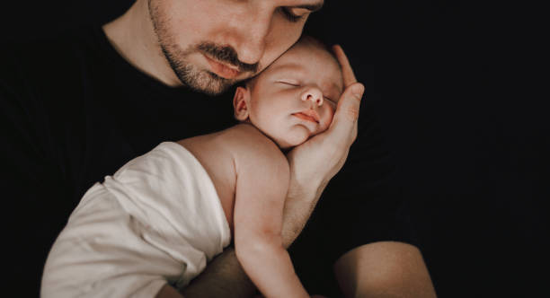 istock Father kissing his newborn baby 1296423237