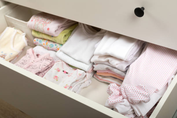 istock Cute newborn clothes in drawer 1296428210