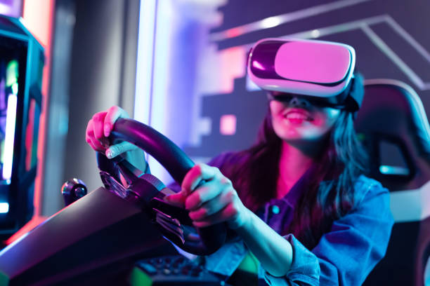 woman play 3D vr game asian woman wears vr glasses and play car racing online video games virtual reality stock pictures, royalty-free photos & images