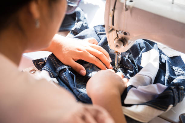 istock image of a woman working in textile project. Sewing with electric machine. 1296436616