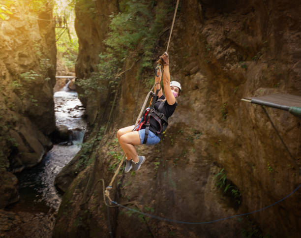 istock Woman hanging from rope swing on canopy tour 1296441089