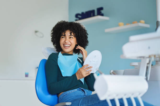 Thank you doc, I love them! Shot of a young woman admiring her teeth after having a dental procedure done dentists chair stock pictures, royalty-free photos & images