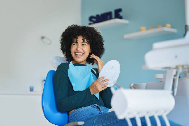 Thank you doc, I love them! Shot of a young woman admiring her teeth after having a dental procedure done dental hygiene stock pictures, royalty-free photos & images