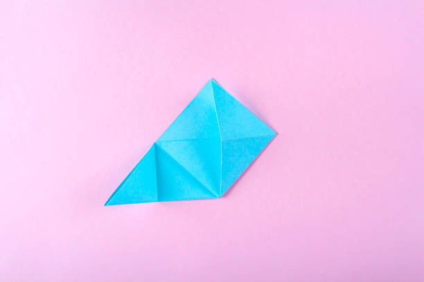 istock DIY and kid's creativity, origami. Step by step instruction: how to make bookmark easter bunny. Step 6 Bend right corner up, and turning down its upper part inward. Easter craft. 1296444481