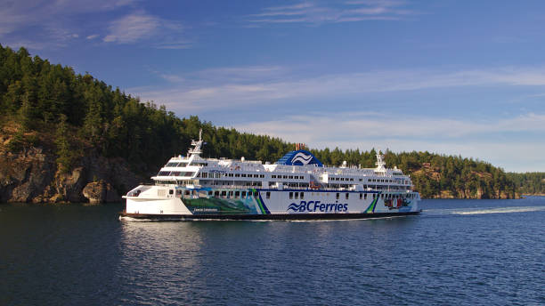 BC Ferries ferry sails close to the shore. Guld Islands, Vancouver, British Columbia, Canada, June 2019 ferry stock pictures, royalty-free photos & images
