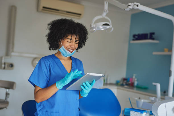 The best digital assistant a dentist could ask for Shot of a young woman using a digital tablet while working in a dentist’s office dental hygienist stock pictures, royalty-free photos & images