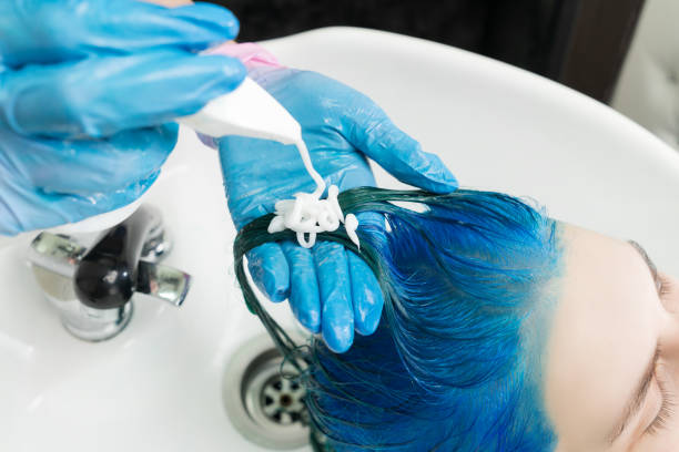 미용사는 튜브에서 부터 고객의 푸른 머리에 샴푸를 짜내고, 뷰티 살롱에서 싱크대와 샤워를 하며 모발을 씻는다. - female hairdresser wet holding 뉴스 사진 이미지