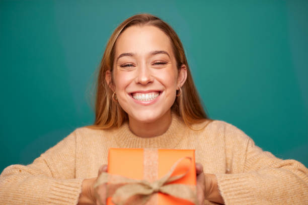istock Happy young woman holding a birthday gift. 1296445577