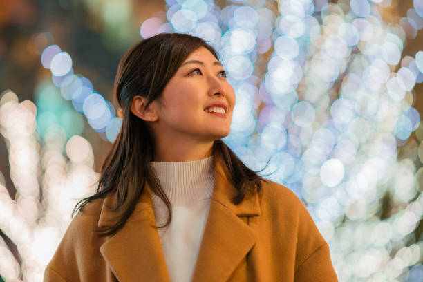 Woman happily walking in street at night in winter A woman is happily walking in the street at night in winter. low angle street japan stock pictures, royalty-free photos & images