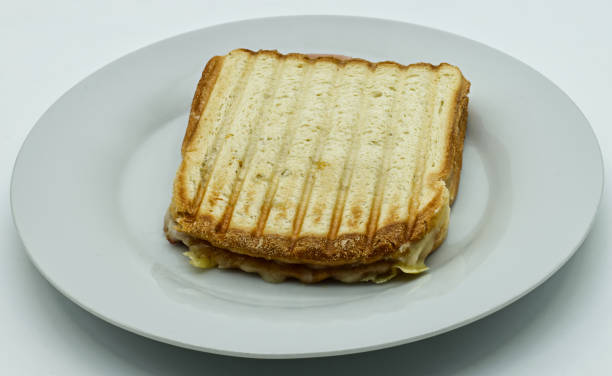 istock Toast bread sandwich ham with melted tilsiter cheese on white dish, isolated on white background 1296448266