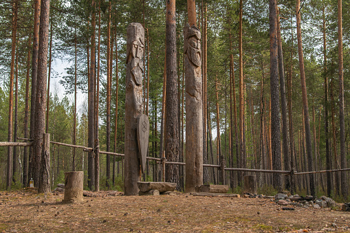 Siberia. A pagan temple in the taiga, with two wooden idols. The image of the pagan Gods is carved on wooden poles.