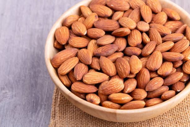 istock Almonds in wooden bowl on table. 1296449672