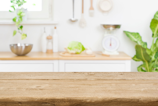 Tablero de mesa de madera en el fondo del mostrador de la sala de cocina borrosa photo