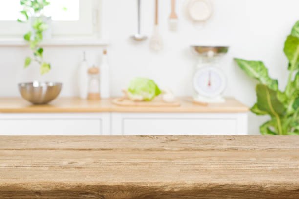 tablero de mesa de madera en el fondo del mostrador de la sala de cocina borrosa - kitchen fotografías e imágenes de stock
