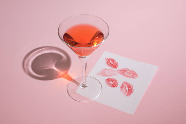 composition rose pastel romantique faite de verre de cocktail et de papier avec des baisers de rouge à lèvres. concept tendance de la saint-valentin. - cocktail alcohol red martini glass photos et images de collection